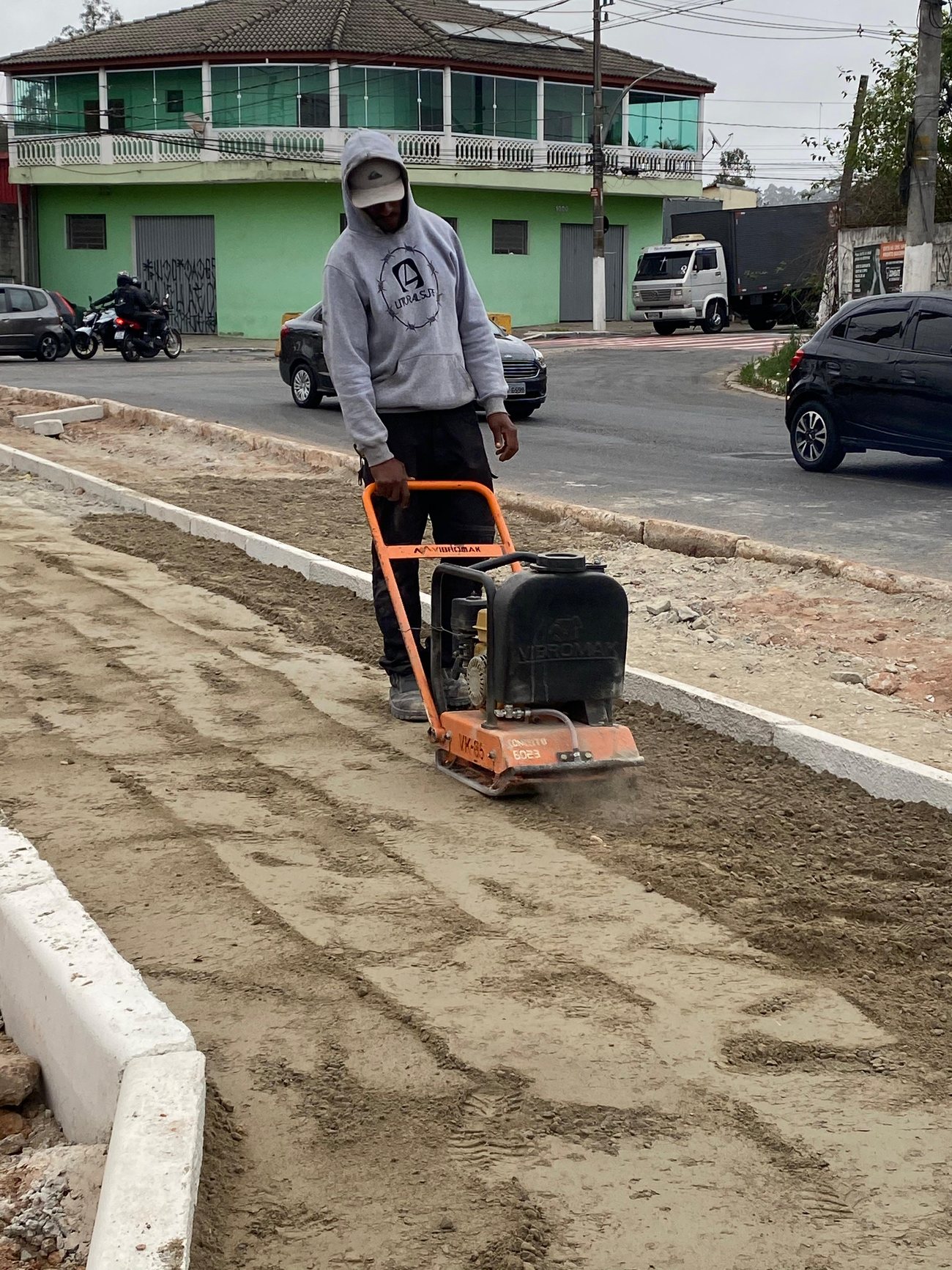 Operador compactando a base com placa vibratória
